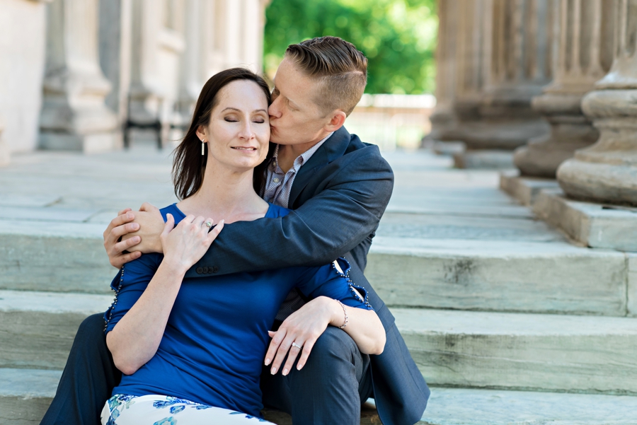 A man kisses his fiance on the steps of a historic building in old city philadelphia.